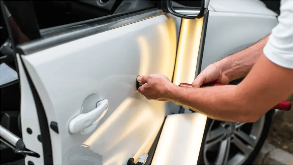 person fixing paint on car door