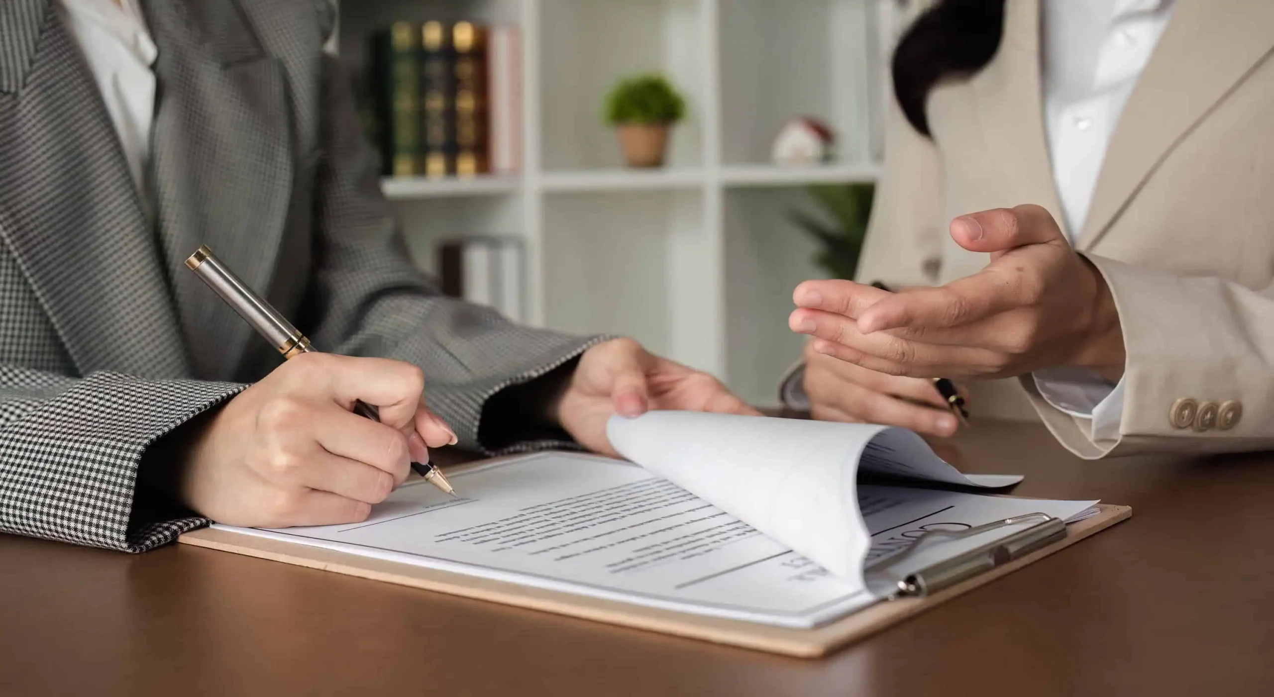 Two people signing paperwork