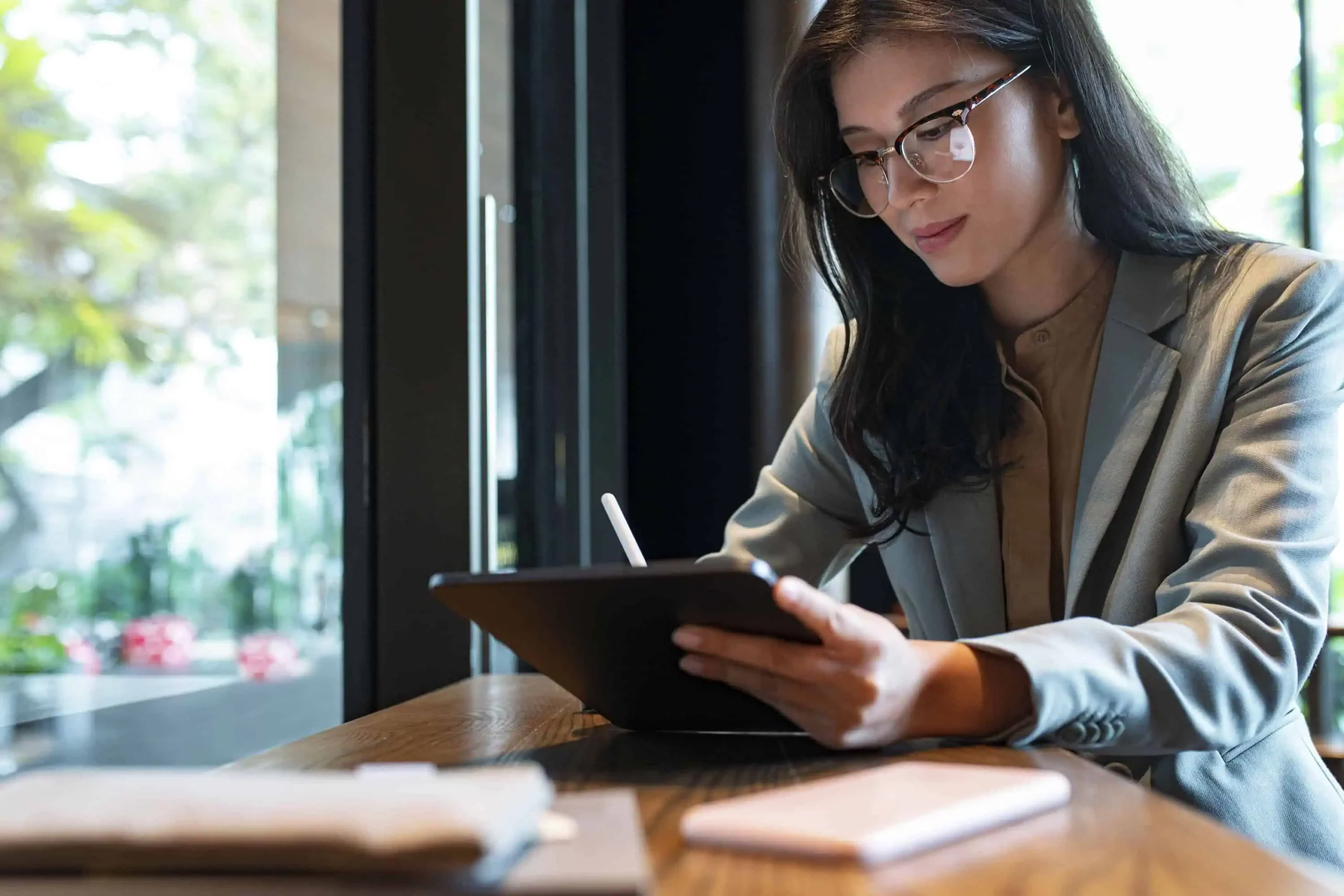Woman at a desk looking at a tablet