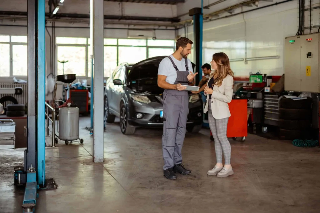 Woman speaking with technician in an auto shop