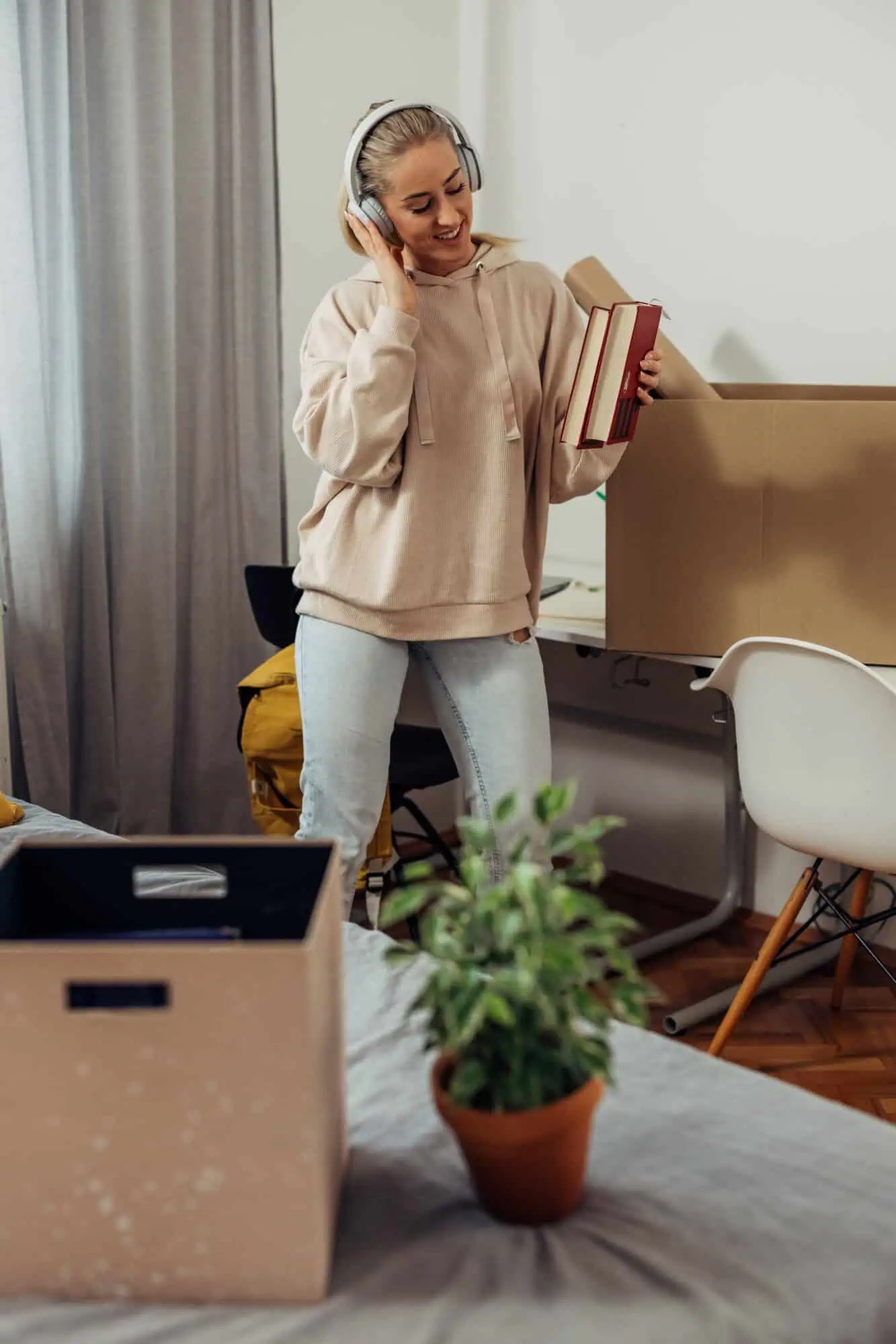 A Girl wearing headphones and unpacking boxes