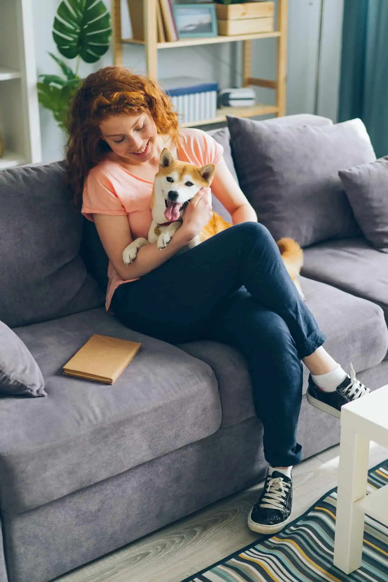 A lady sitting on a couch with dog in lap